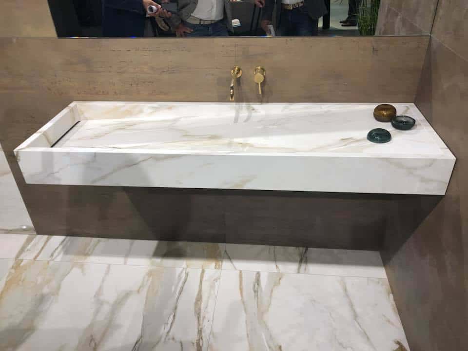 Lavabo in marmo con finiture moderne e dettagli dorati, perfetto per ambienti di design.